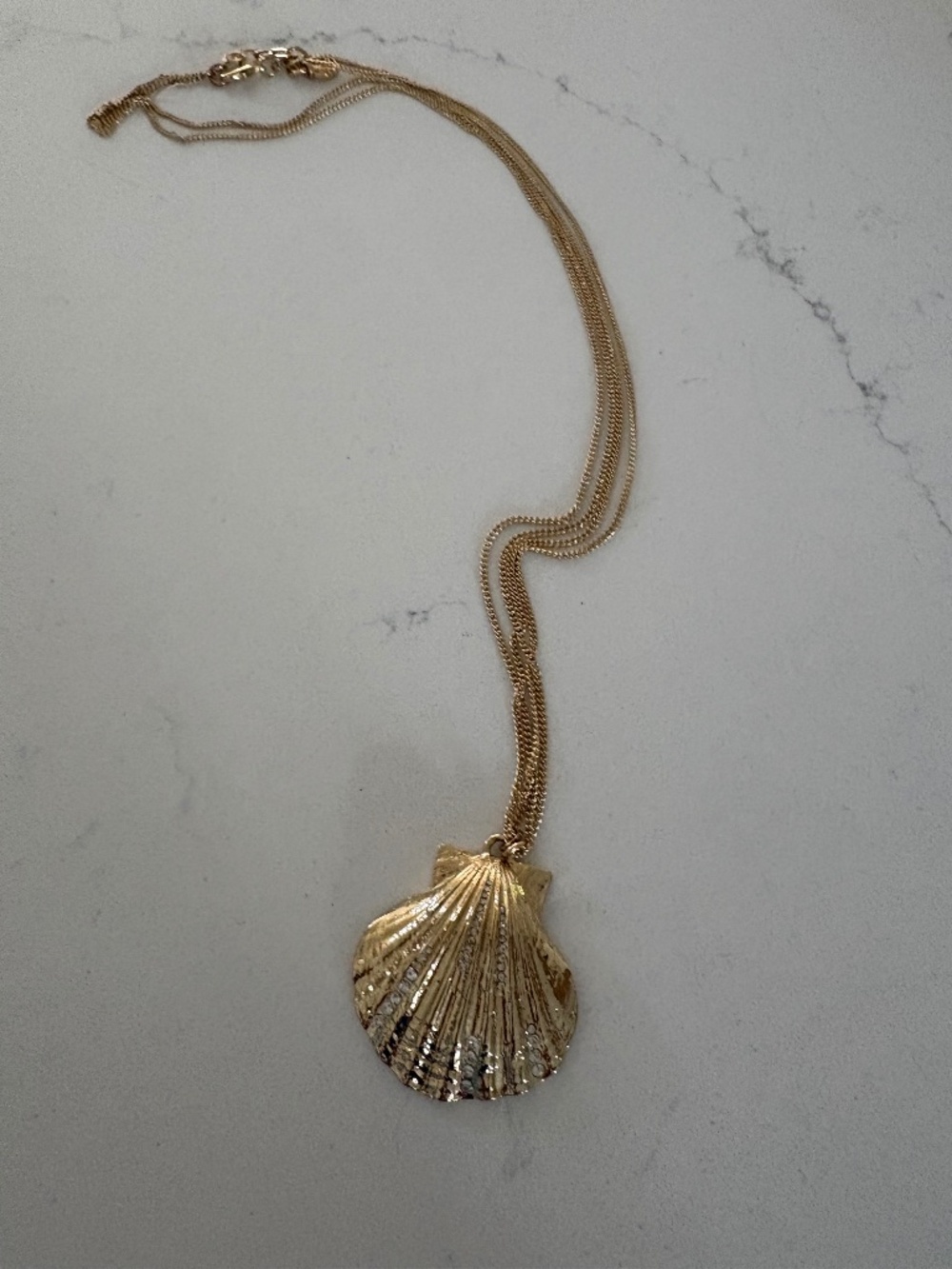 Long double chained gold necklace with clam shell pendant